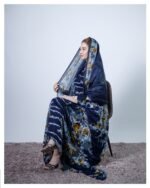 ثوب أزرق اللون مصنوع من القطن بتصميم باللون الرمادي مطبوع عليه شيلة متناسقة مخيطة على الطراز الظفاري