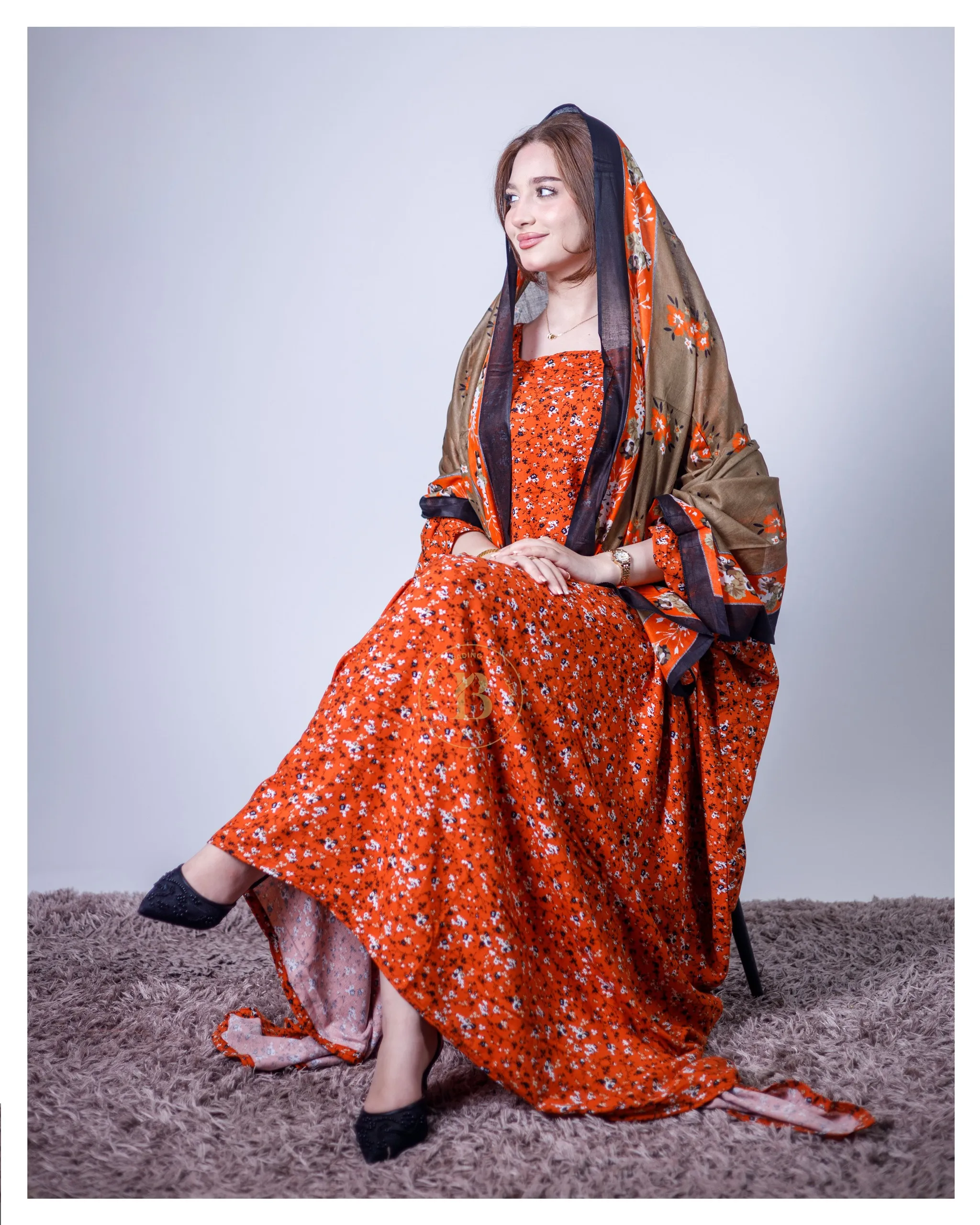 ثوب برتقالي اللون مصنوع من القطن، مزين بطبعة زهور جميلة، مع شيلة متناسقة، ومخيط على الطراز الظفاري