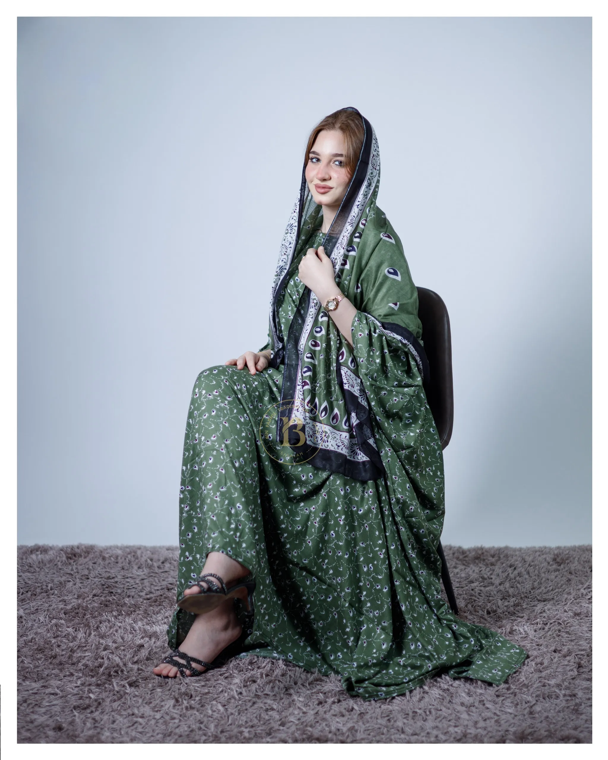 ثوب أخضر اللون مصنوع من القطن، مزين بتصميم جميل مطبوع عليه شيلة متناسقة ومخيط على الطراز الظفاري