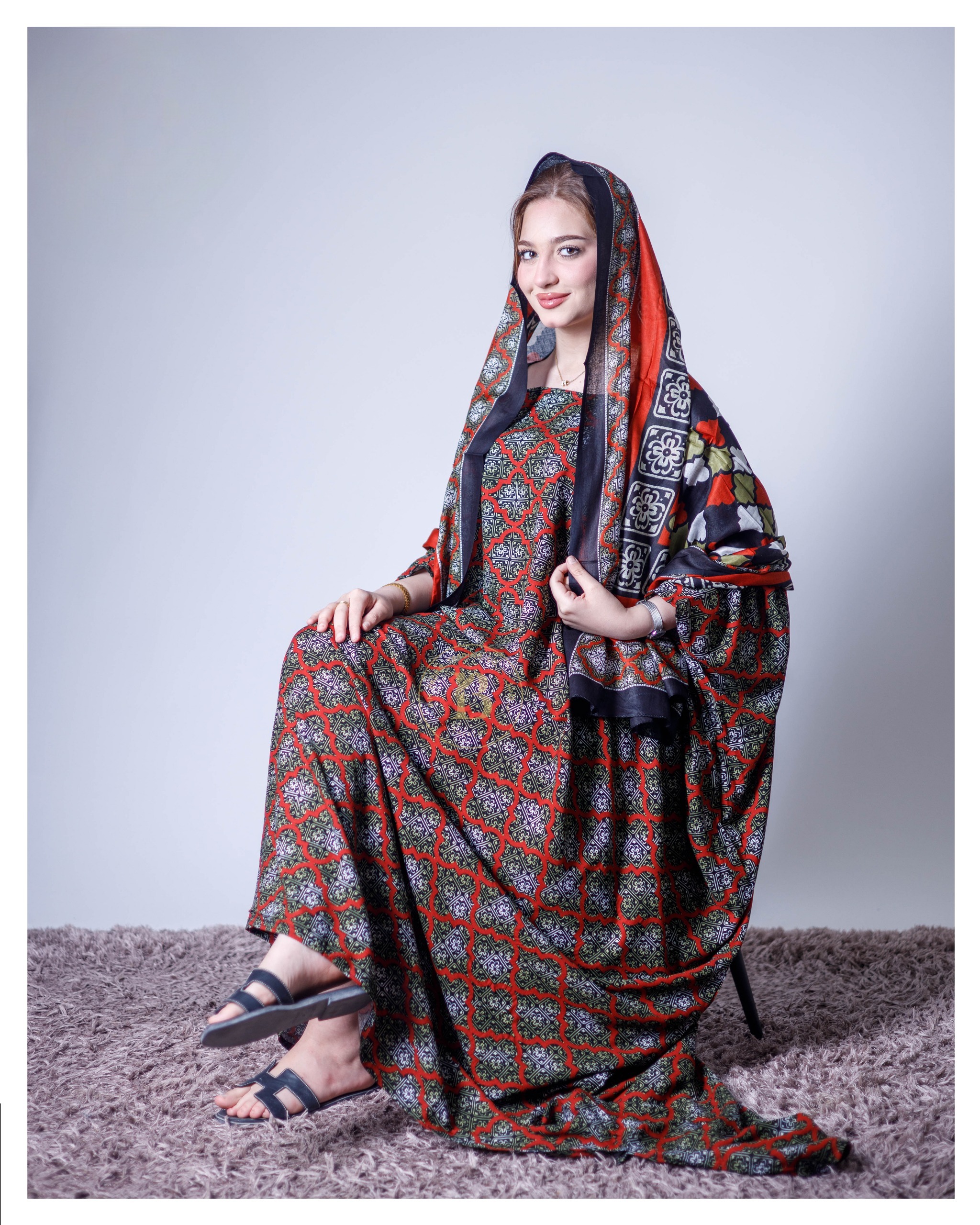 ثوب جميل اللون مصنوع من القطن، مزين بتصميم جميل مطبوع عليه شيلة متناسقة، ومخيط على الطراز الظفاري