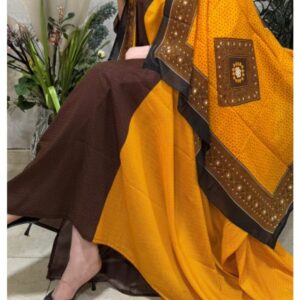 ثوب قطني بلون أصفر وعنابي، مزين بتصميم جميل مطبوع عليه شيلة متناسقة، ومخيط على الطراز الظفاري