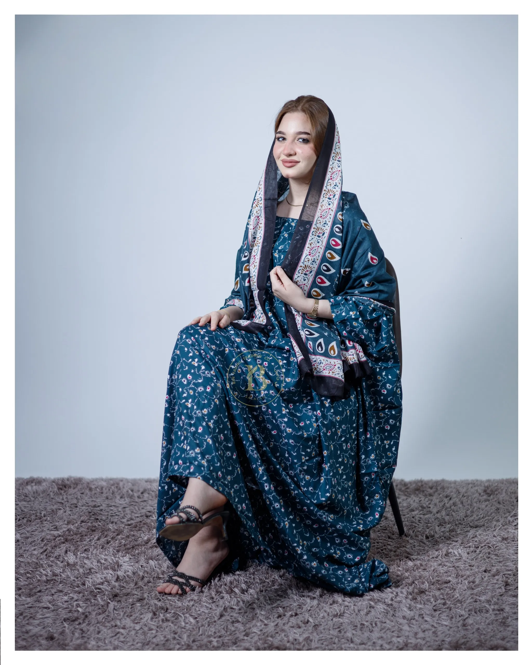 ثوب أزرق اللون مصنوع من القطن، مزين بتصميم جميل مطبوع عليه شيلة متناسقة، ومخيط على الطراز الظفاري