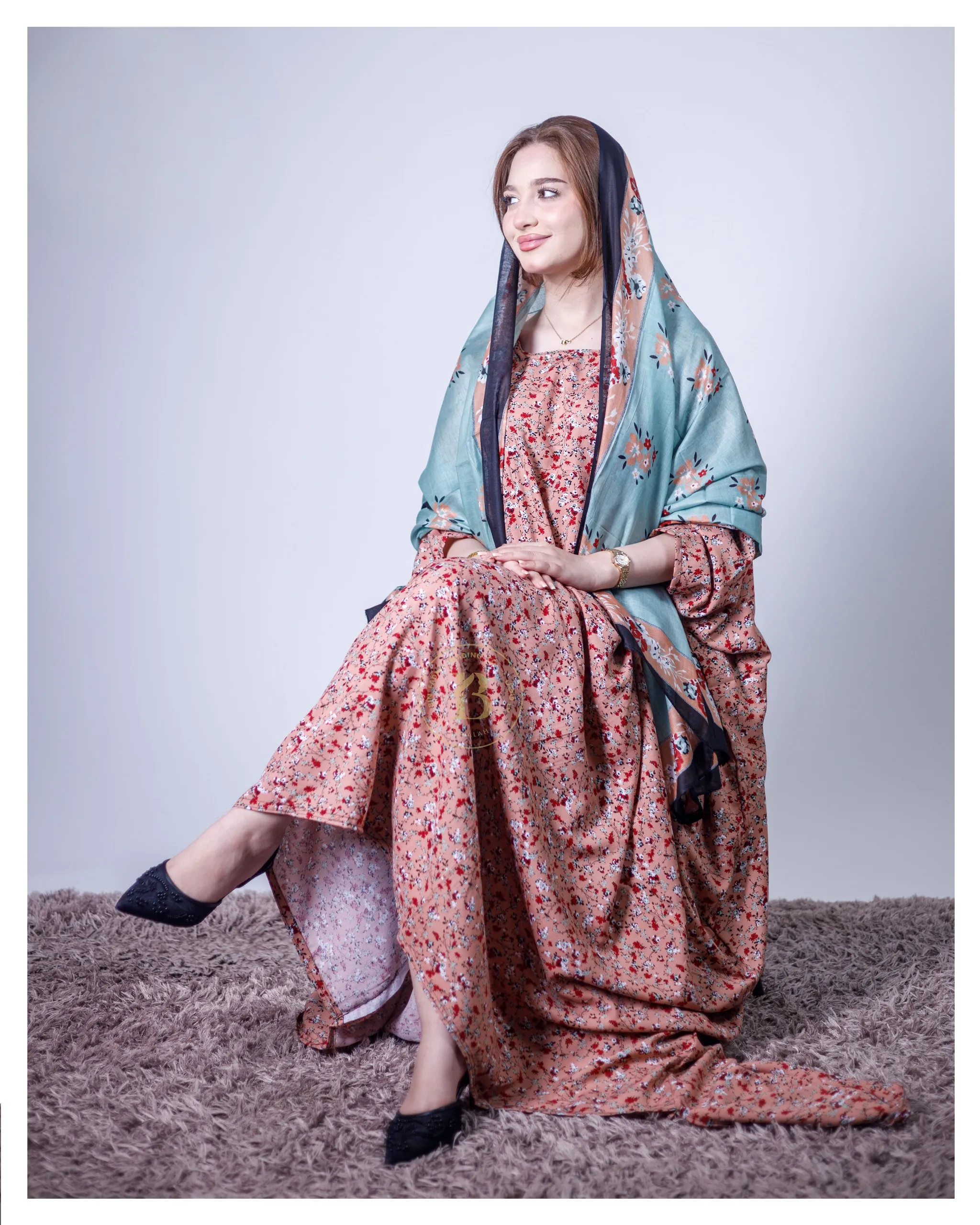 ثوب بلون وردي فاتح مصنوع من القطن، مزين بطبعة زهور جميلة، مع شيلة متناسقة، ومخيط على الطراز الظفاري