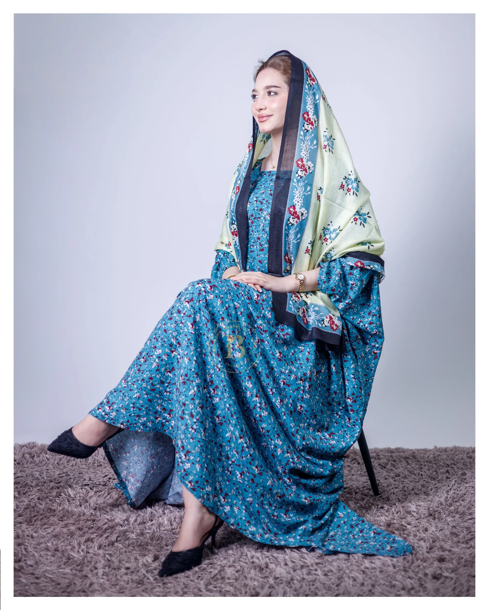 ثوب بلون الفيروزي مصنوع من القطن، مزين بطبعة زهور جميلة، مع شيلة متناسقة، ومخيط على الطراز الظفاري