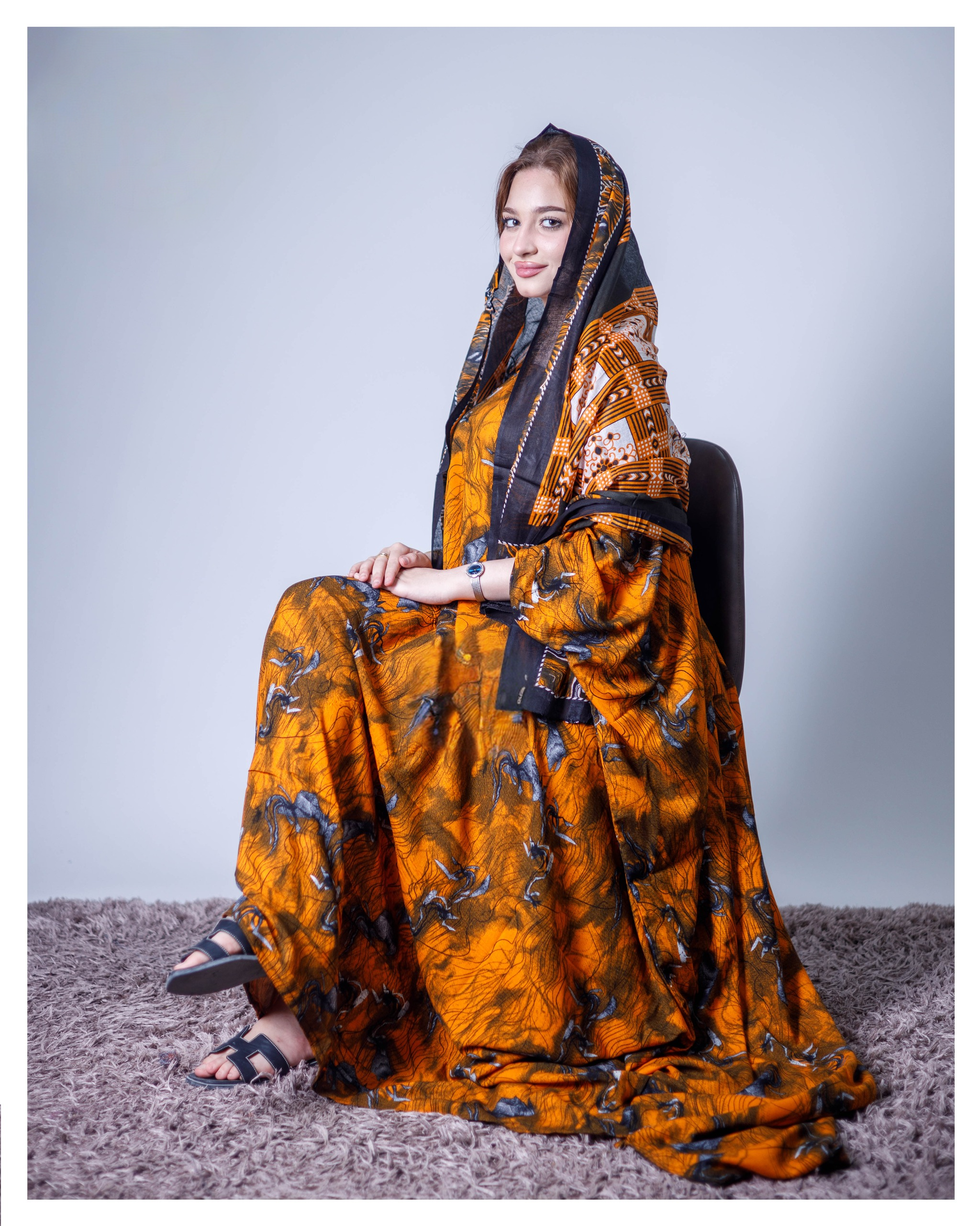 ثوب بلون برتقالي مصنوع من القطن بتصميم جميل مطبوع عليه شيلة متناسقة ومخيطة على الطراز الظفاري