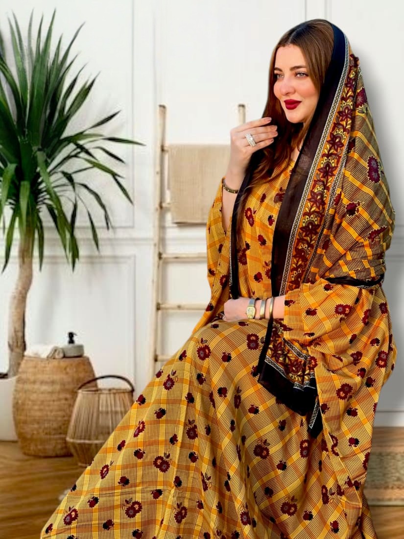 ثوب أصفر اللون مصنوع من القطن بتصميم جميل مطبوع عليه شيلة متناسقة مخيطة على الطراز الظفاري