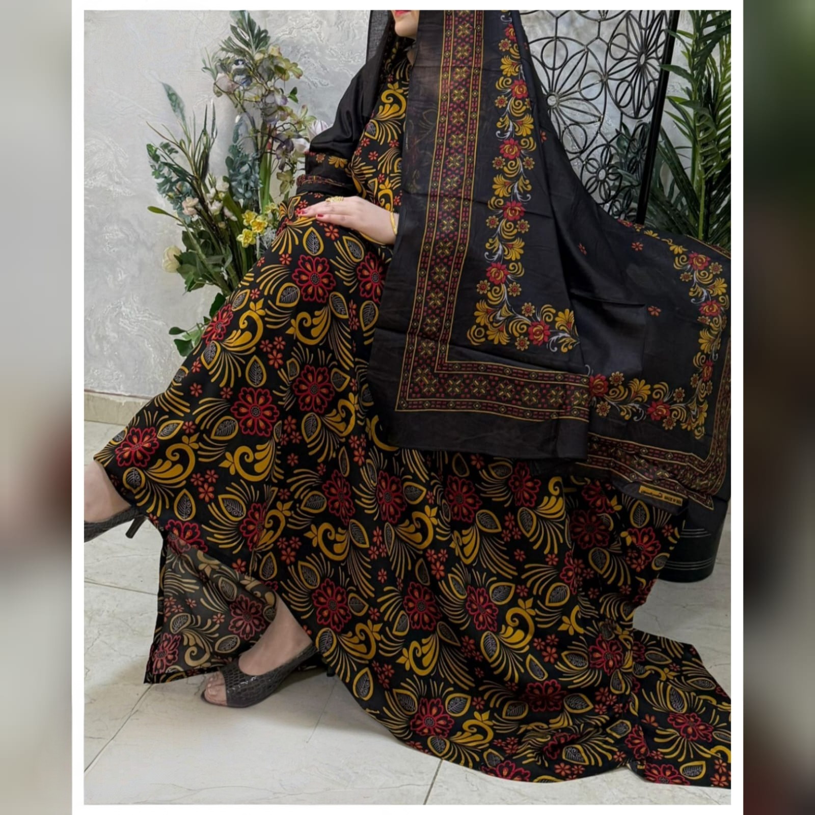 ثوب أسود اللون مصنوع من القطن مع تصميم زهور جميل مطبوع ومزين بشيلة متناسقة مخيطة على الطراز الظفاري